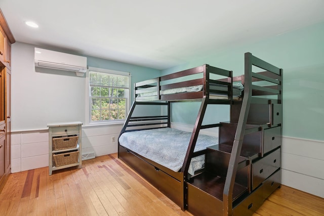 53 Beach Ave, Kennebunk, ME 04043 - bedroom with a wall mounted air conditioner, light wood finished floors, wainscoting, and recessed lighting