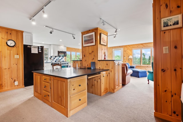11 Overlook Rd, Rangeley, ME 04970 - kitchen with track lighting, black appliances, dark countertops, wooden walls, and light carpet