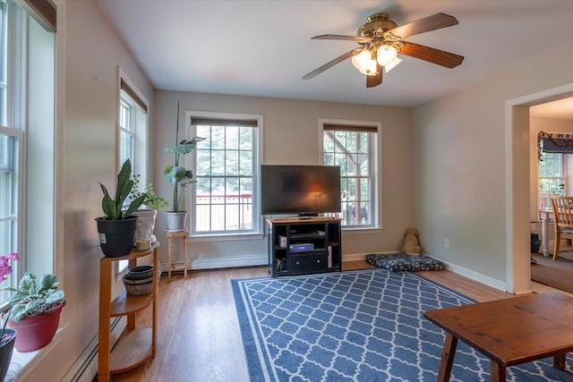 415 Waldoboro Rd, Jefferson, ME 04348 - living room with wood finished floors, a ceiling fan, and a baseboard heating unit