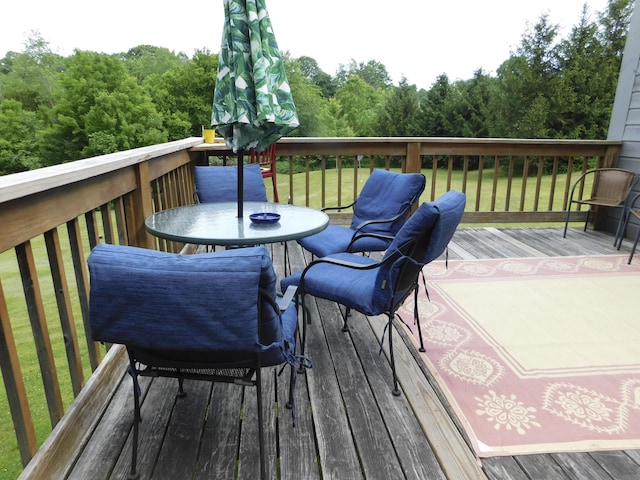 170 Main St, Sangerville, ME 04479 - wooden deck featuring outdoor dining space, a yard, and a view of trees