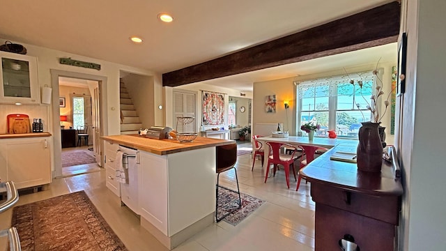 25 Church St, Lubec, ME 04652 - kitchen featuring wood counters, white cabinetry, recessed lighting, glass insert cabinets, and a kitchen bar