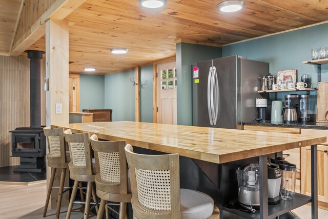 7 Papoose Island Rd, Raymond, ME 04071 - kitchen with butcher block countertops, open shelves, freestanding refrigerator, wooden ceiling, and a breakfast bar area