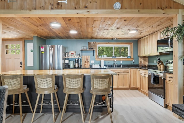 7 Papoose Island Rd, Raymond, ME 04071 - kitchen featuring stainless steel appliances, light wood-style floors, wooden ceiling, dark countertops, and light brown cabinetry