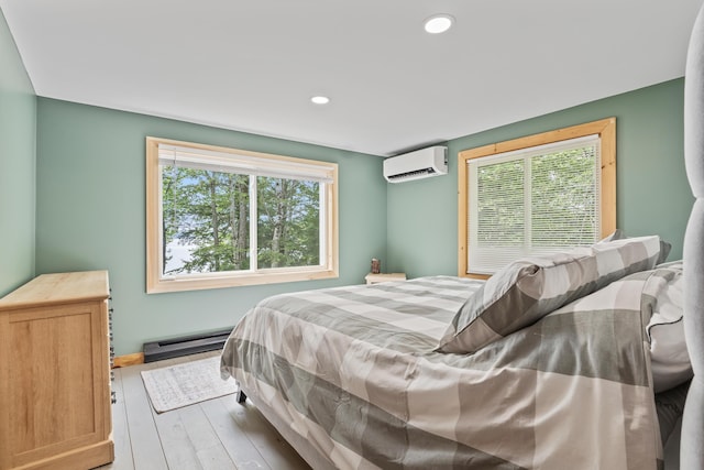 7 Papoose Island Rd, Raymond, ME 04071 - bedroom with a wall mounted AC, a baseboard radiator, multiple windows, wood finished floors, and recessed lighting