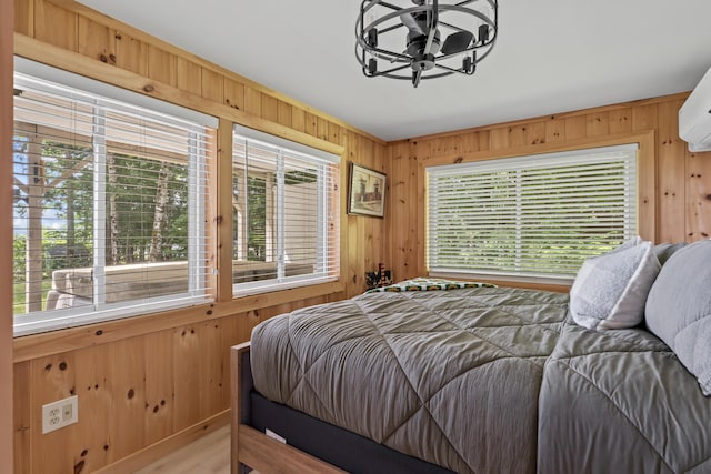 7 Papoose Island Rd, Raymond, ME 04071 - bedroom featuring wood walls, multiple windows, and a chandelier