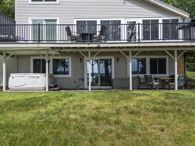 7 Papoose Island Rd, Raymond, ME 04071 - back of house with a hot tub, a lawn, and a patio area