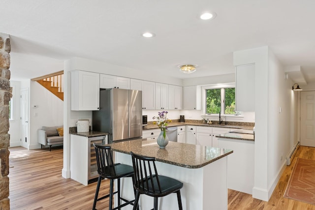 2 Far View Cir, Saco, ME 04072 - kitchen featuring a baseboard heating unit, stainless steel appliances, white cabinetry, a kitchen bar, and recessed lighting