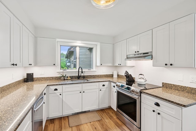 2 Far View Cir, Saco, ME 04072 - kitchen featuring appliances with stainless steel finishes, under cabinet range hood, light wood finished floors, white cabinets, and dark stone countertops