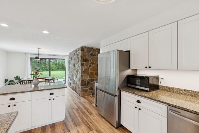 2 Far View Cir, Saco, ME 04072 - kitchen featuring appliances with stainless steel finishes, white cabinetry, light wood finished floors, dark stone counters, and pendant lighting