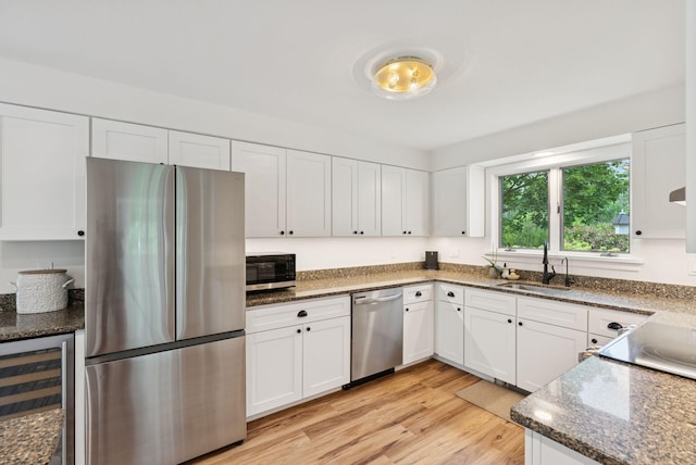 2 Far View Cir, Saco, ME 04072 - kitchen featuring appliances with stainless steel finishes, wine cooler, white cabinetry, and dark stone counters
