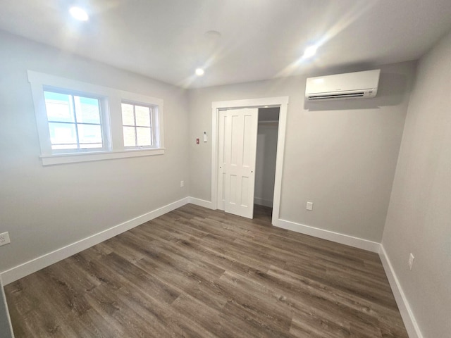 106 Cumberland Ave Unit 201, Portland, ME 04101 - unfurnished bedroom featuring a wall mounted AC, dark wood-style floors, a closet, and recessed lighting