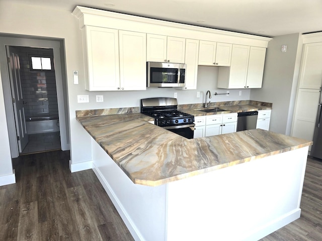 106 Cumberland Ave Unit 201, Portland, ME 04101 - kitchen featuring appliances with stainless steel finishes, dark wood-style floors, white cabinetry, and a peninsula