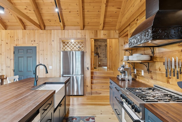 7 Coven Hill Ln, South Bristol, ME 04568 - kitchen with butcher block counters, stainless steel appliances, open shelves, wooden walls, and light wood-style flooring