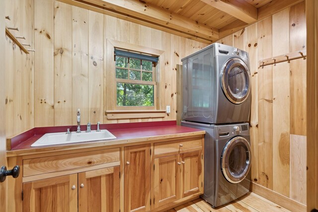 7 Coven Hill Ln, South Bristol, ME 04568 - laundry room featuring stacked washer and clothes dryer, cabinet space, wooden ceiling, wood walls, and light wood-style floors