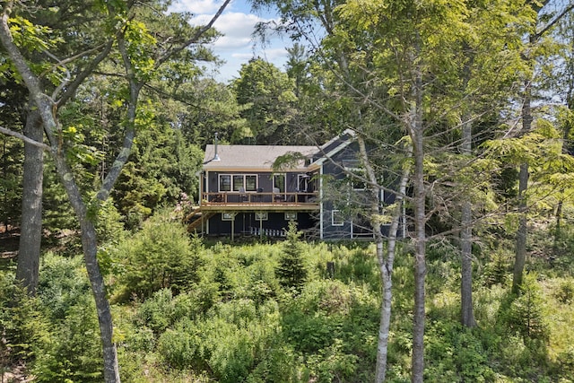 7 Coven Hill Ln, South Bristol, ME 04568 - rear view of property featuring a deck, a view of trees, and a chimney