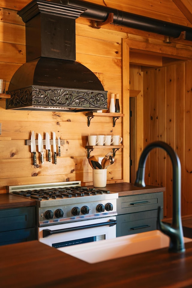 7 Coven Hill Ln, South Bristol, ME 04568 - kitchen with range hood, gas stove, wooden walls, and dark countertops