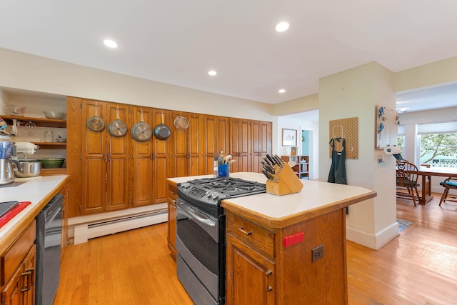 390 Front St, Bath, ME 04530 - kitchen featuring stainless steel gas range, a baseboard radiator, light countertops, a kitchen island, and light wood-style flooring