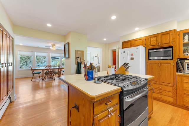 390 Front St, Bath, ME 04530 - kitchen featuring stainless steel appliances, light wood-type flooring, a kitchen island, a baseboard radiator, and light countertops