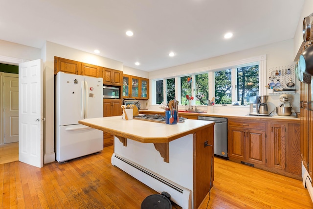 390 Front St, Bath, ME 04530 - kitchen featuring stainless steel appliances, a baseboard heating unit, light wood-style flooring, light countertops, and brown cabinets