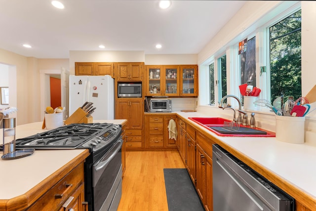 390 Front St, Bath, ME 04530 - kitchen featuring stainless steel appliances, brown cabinets, light countertops, light wood-style floors, and recessed lighting