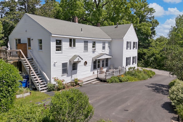 390 Front St, Bath, ME 04530 - view of front of home featuring a deck, view of wooded area, a chimney, and a shingled roof