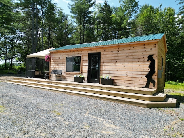 1093 N Chester Rd, Chester, ME 04457 - view of front of house with a metal roof, a sunroom, and a wooden deck
