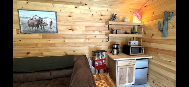 1093 N Chester Rd, Chester, ME 04457 - kitchen featuring stainless steel microwave, wooden walls, lofted ceiling, and light countertops