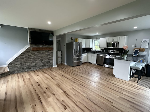 64 Litchfield Rd, Bowdoin, ME 04287 - kitchen featuring stainless steel appliances, white cabinets, a peninsula, and light wood-style floors