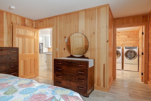 51 Short Point Way, Orland, ME 04472 - bedroom featuring separate washer and dryer, light wood-style floors, wooden walls, and freestanding refrigerator