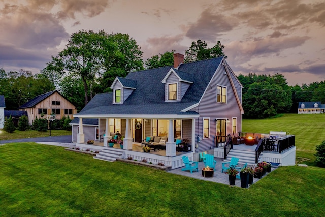 352 River Rd, Eliot, ME 03903 - back of property at dusk with an outdoor living space with a fire pit, a chimney, a lawn, roof with shingles, and a wooden deck
