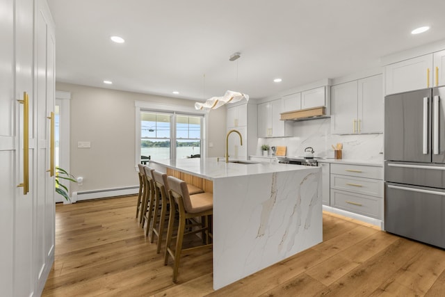 352 River Rd, Eliot, ME 03903 - kitchen with freestanding refrigerator, a baseboard radiator, light wood-style flooring, recessed lighting, and light stone countertops