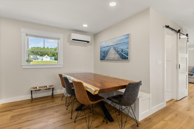 352 River Rd, Eliot, ME 03903 - dining room with a wall mounted AC, a barn door, light wood-style floors, and recessed lighting