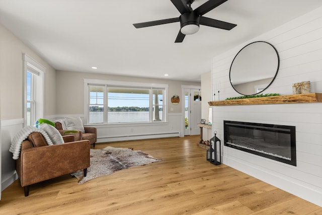 352 River Rd, Eliot, ME 03903 - living area featuring a baseboard heating unit, a glass covered fireplace, light wood-type flooring, a ceiling fan, and recessed lighting