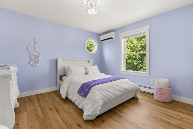 352 River Rd, Eliot, ME 03903 - bedroom with a wall mounted air conditioner, a baseboard heating unit, and light wood-style flooring