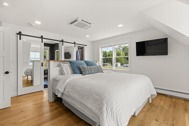 352 River Rd, Eliot, ME 03903 - bedroom featuring a baseboard radiator, multiple windows, recessed lighting, and light wood-type flooring