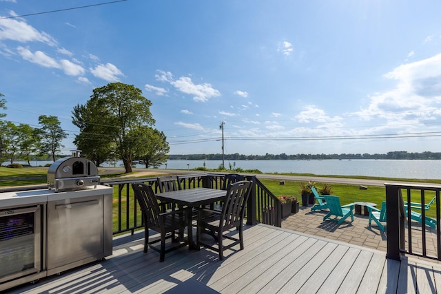 352 River Rd, Eliot, ME 03903 - wooden deck featuring outdoor dining area, a water view, a lawn, grilling area, and an outdoor fire pit