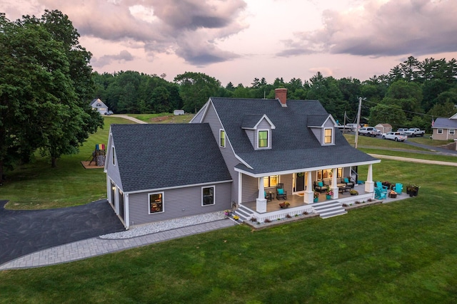352 River Rd, Eliot, ME 03903 - view of front of house with covered porch, a chimney, roof with shingles, driveway, and a yard