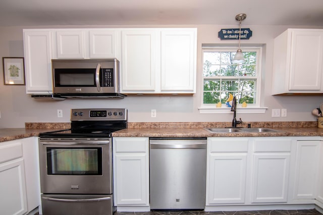 9 St James Pl, Lewiston, ME 04240 - kitchen featuring stainless steel appliances, white cabinetry, and hanging light fixtures
