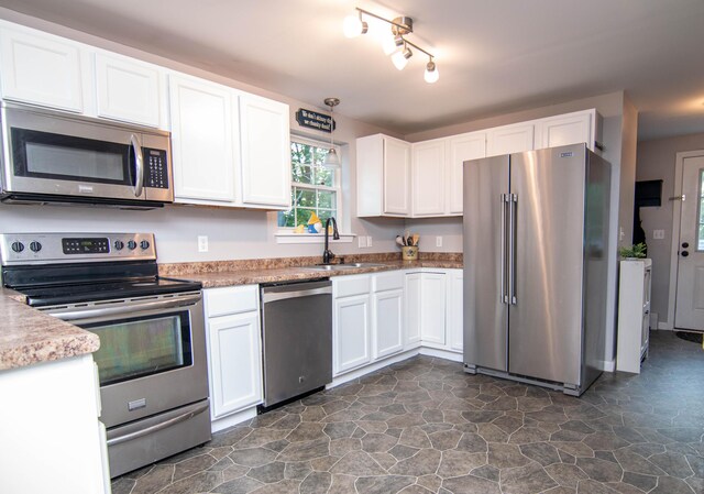9 St James Pl, Lewiston, ME 04240 - kitchen with stainless steel appliances, white cabinetry, dark stone finish floors, light countertops, and track lighting