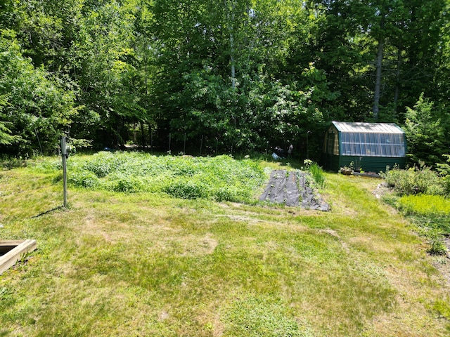 25 Loop Rd, Chester, ME 04457 - view of green lawn with a greenhouse, an outbuilding, and a view of trees