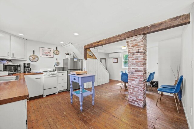 3 Surf Ave, Biddeford, ME 04005 - kitchen featuring ornate columns, appliances with stainless steel finishes, a wall mounted AC, hardwood / wood-style floors, and recessed lighting