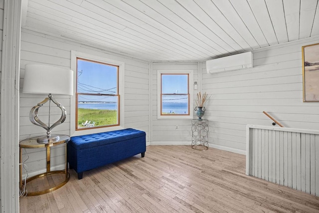 3 Surf Ave, Biddeford, ME 04005 - sitting room featuring a wall unit AC, healthy amount of natural light, wood ceiling, wood finished floors, and wooden walls