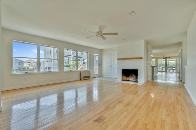 9 Riverside Ave, Saco, ME 04072 - unfurnished living room with a ceiling fan, light wood-type flooring, a fireplace with flush hearth, and heating unit