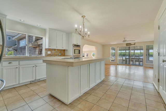 9 Riverside Ave, Saco, ME 04072 - kitchen with light tile patterned floors, open floor plan, arched walkways, stainless steel oven, and light countertops