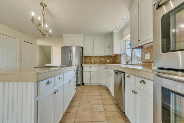 9 Riverside Ave, Saco, ME 04072 - kitchen with stainless steel appliances, decorative backsplash, white cabinetry, decorative light fixtures, and recessed lighting