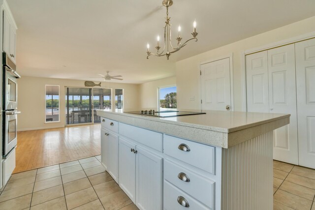 9 Riverside Ave, Saco, ME 04072 - kitchen with light tile patterned flooring, a kitchen island, light countertops, a chandelier, and open floor plan