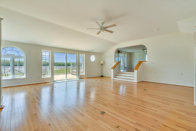9 Riverside Ave, Saco, ME 04072 - unfurnished living room featuring a ceiling fan, vaulted ceiling, stairs, light wood finished floors, and arched walkways