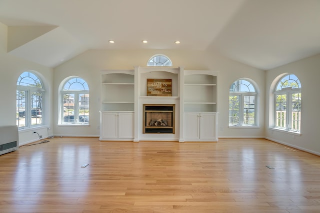 9 Riverside Ave, Saco, ME 04072 - unfurnished living room featuring vaulted ceiling, light wood-type flooring, a glass covered fireplace, recessed lighting, and built in features