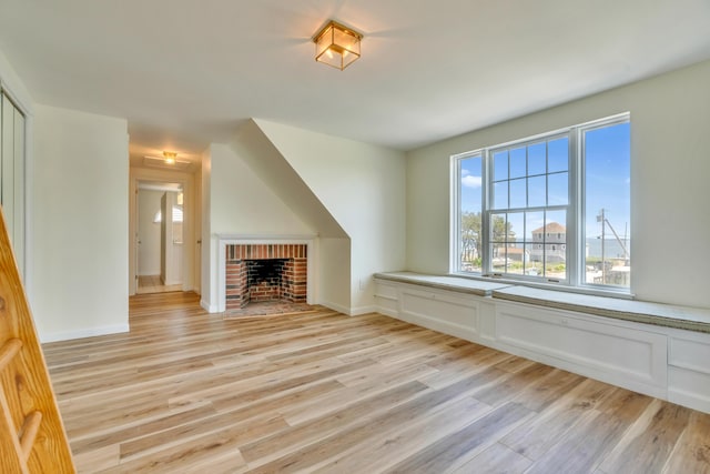 9 Riverside Ave, Saco, ME 04072 - unfurnished living room with light wood-style floors and a brick fireplace