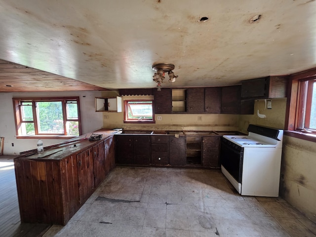 67 Back Searsport Rd, Searsport, ME 04974 - kitchen featuring white range with electric stovetop, plenty of natural light, dark brown cabinets, and a peninsula